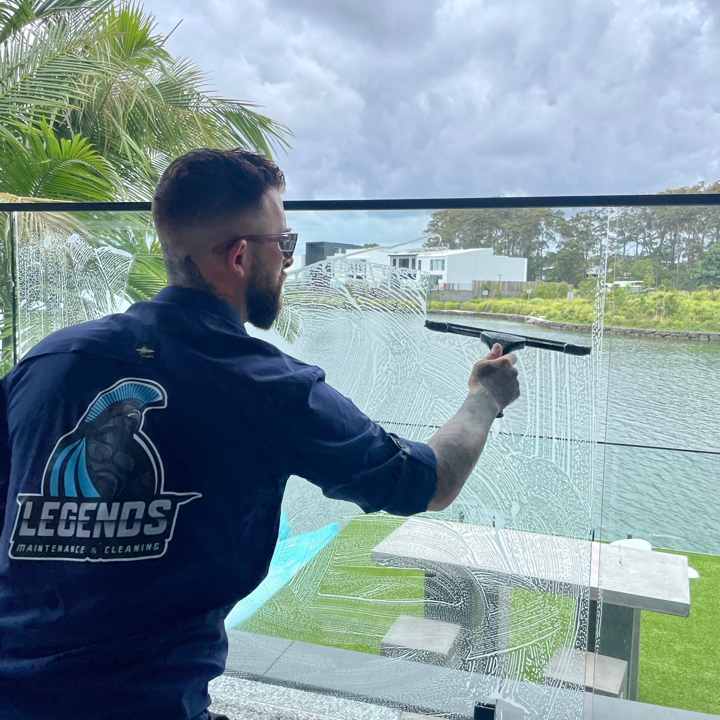 Man cleaning glass waterfront view