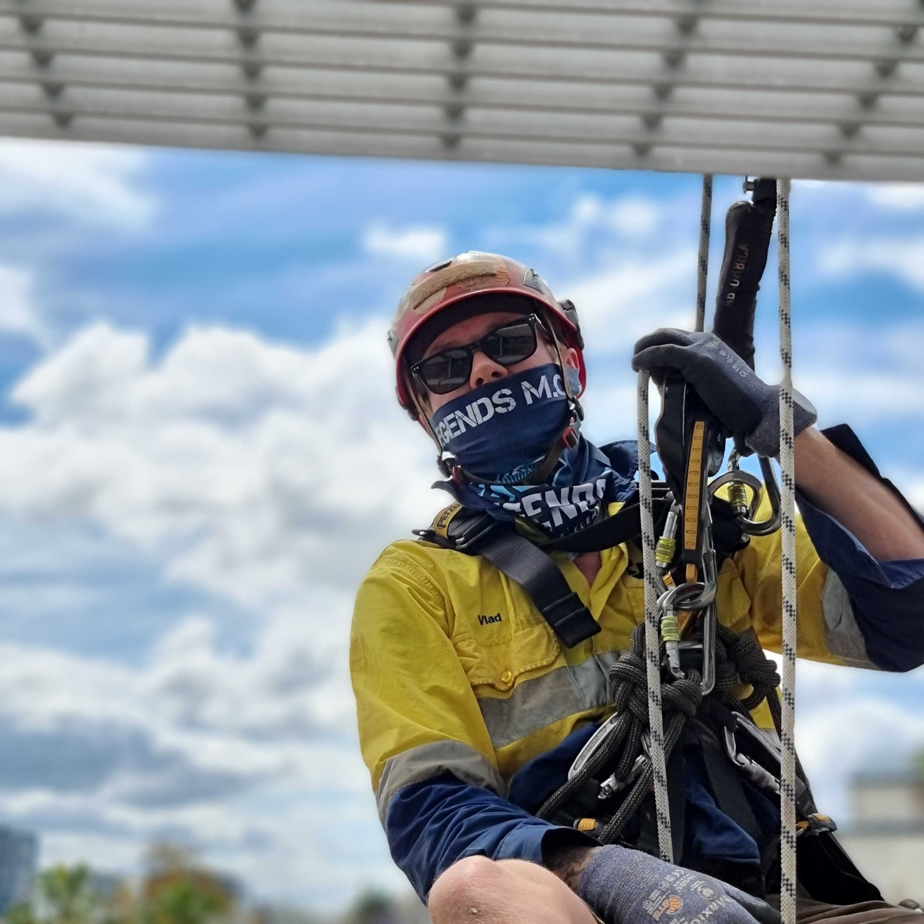 Person rappelling down structure with rope