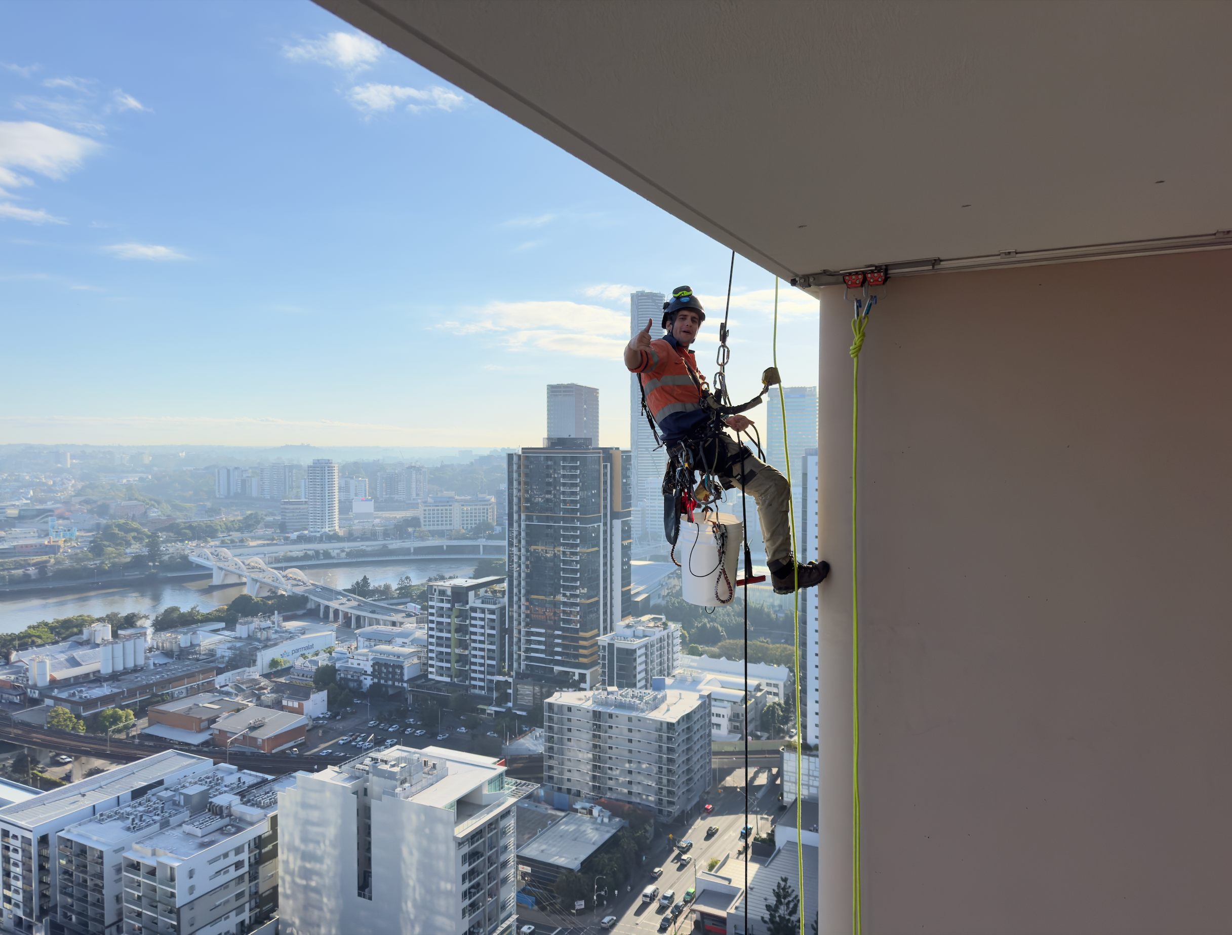 Window cleaner rappelling high-rise building