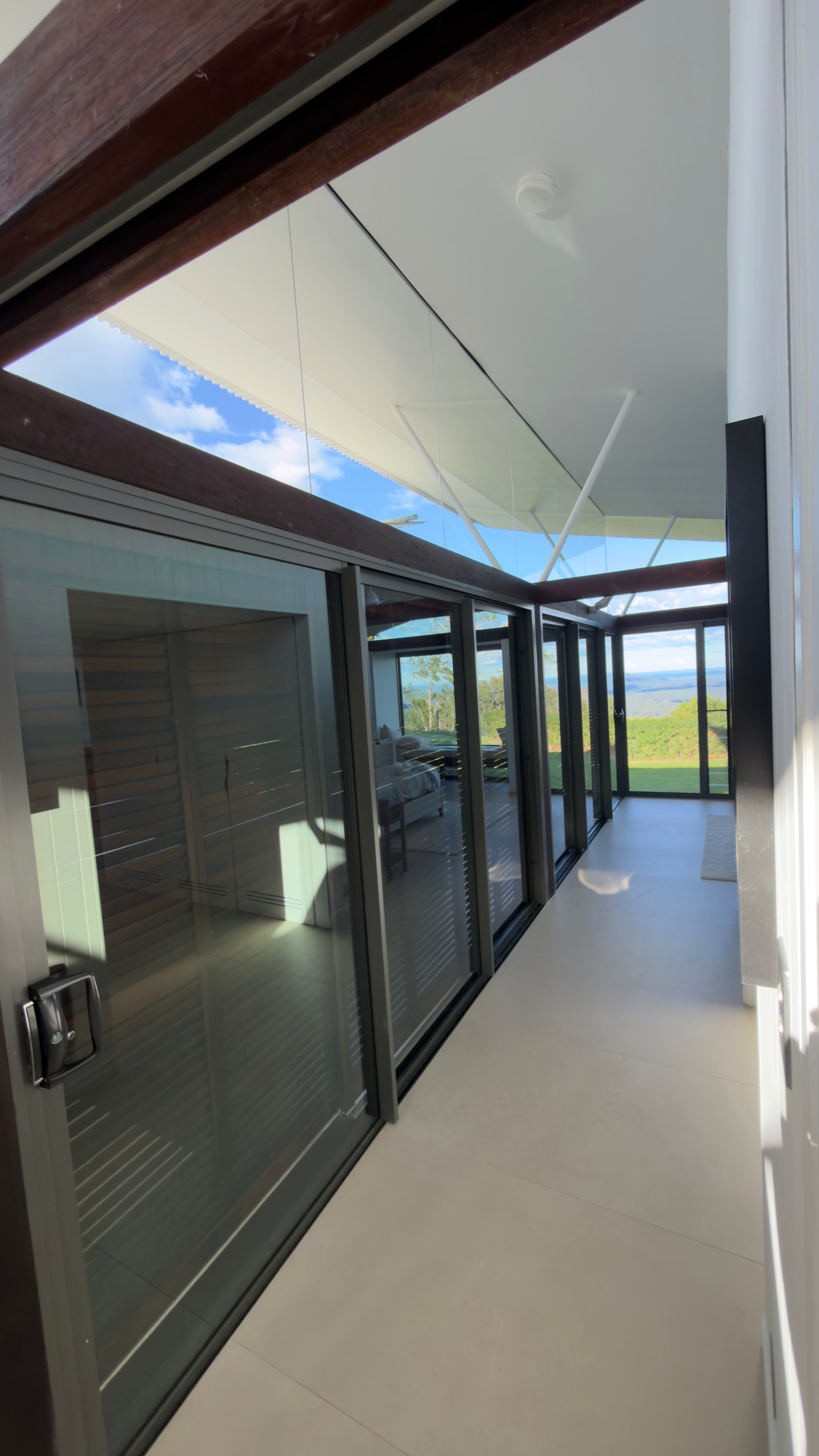 Modern sunroom with glass doors countryside view