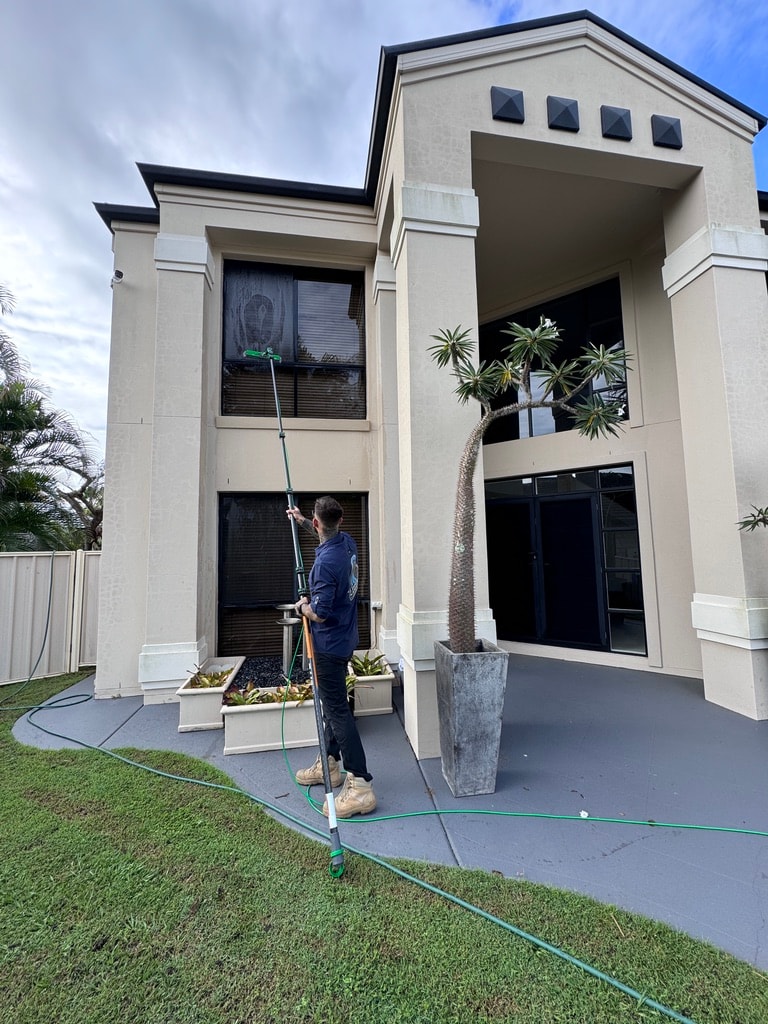 Man cleaning glass railing waterfront
