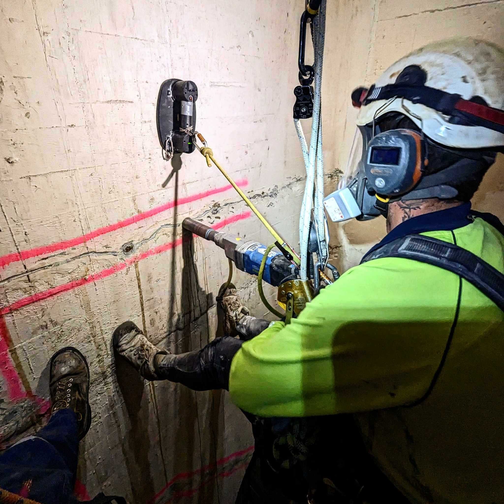 Climber rappelling down concrete wall